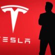 Elon Musk silhouette with Tesla logo in background