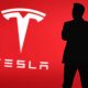 Elon Musk silhouette with Tesla logo in background